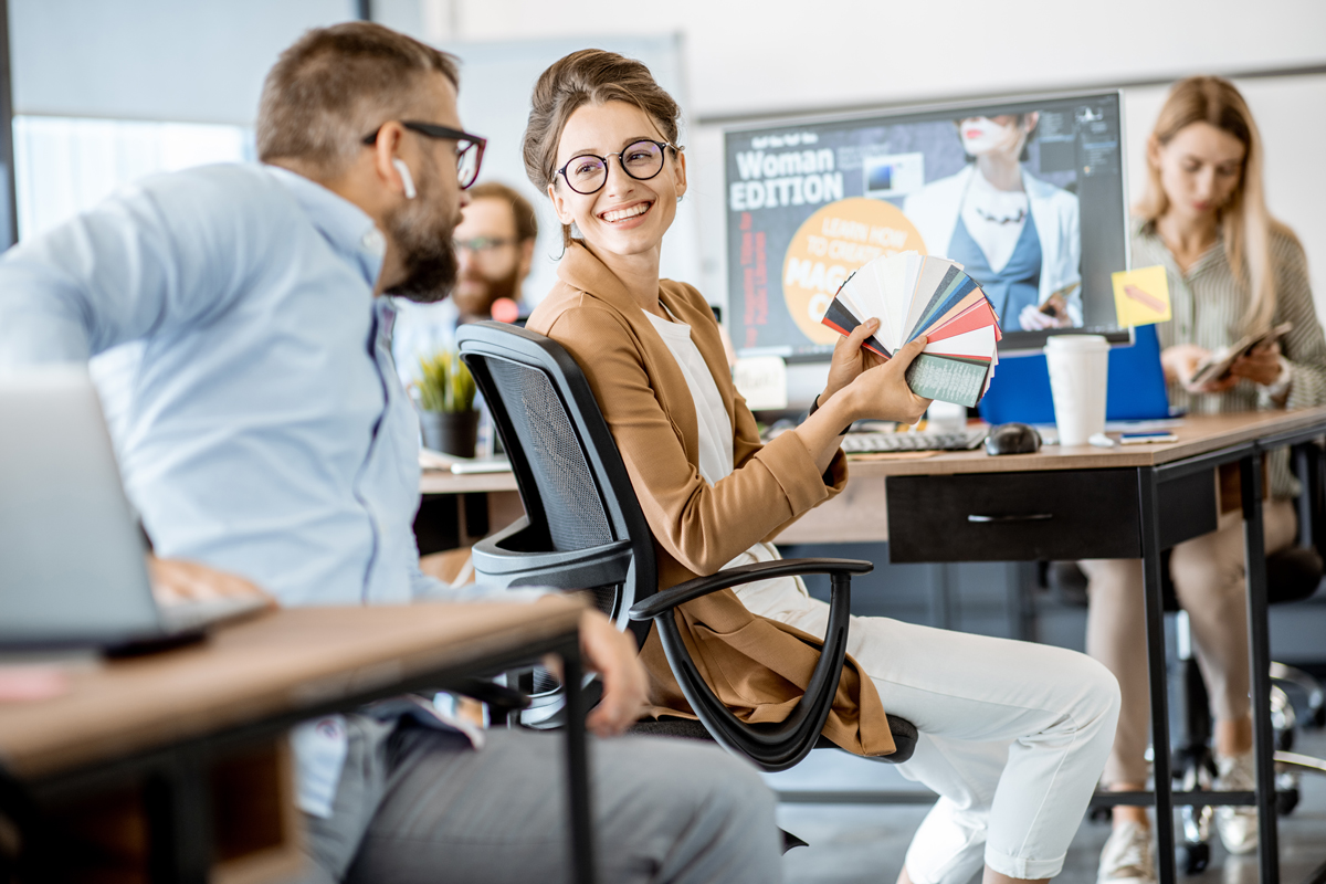 Group of creative and happy coworkers working on web design with computers in the office