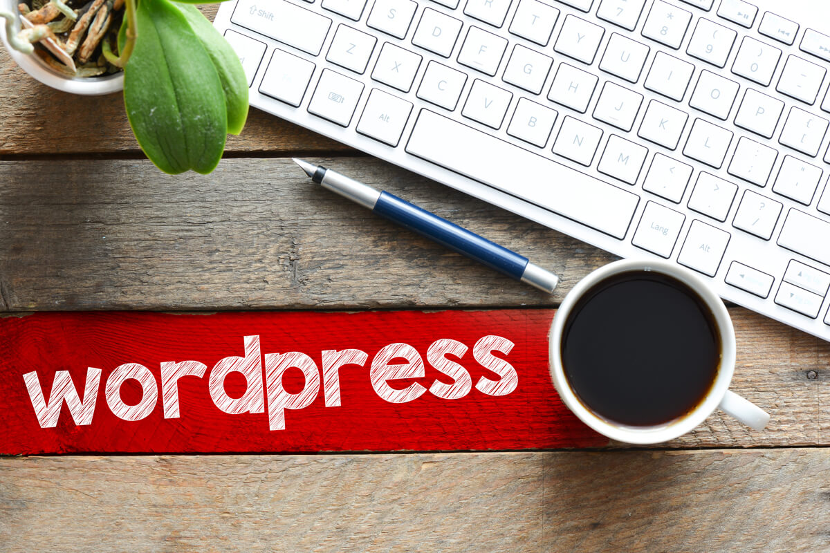 top view of coffee cup and keyboard with wordpress inscription on table