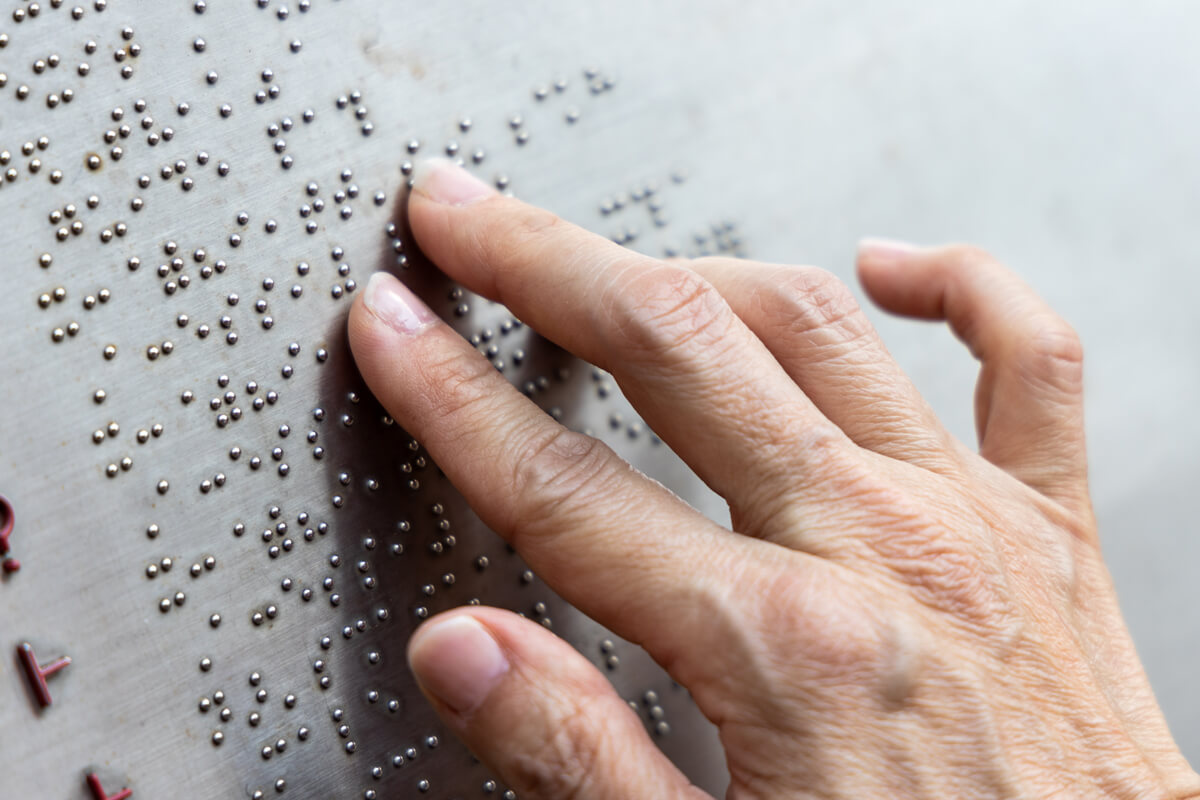 Finger reading braille tactile on public park message board in Hong Kong