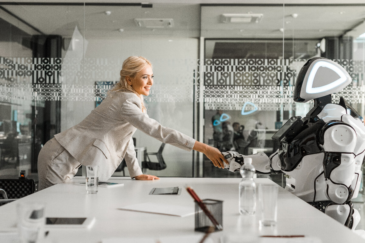 Smiling business woman shaking hand with robot